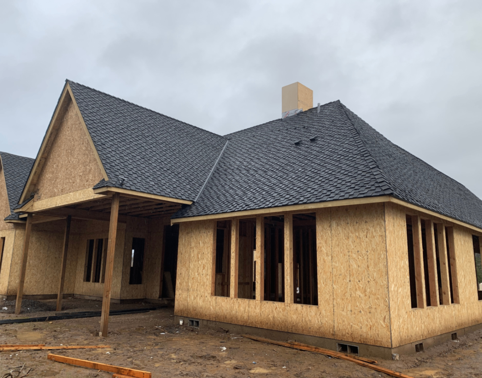New construction home with a completed dark architectural shingle roof